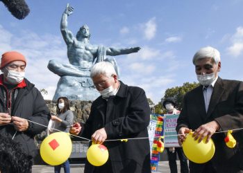 Asistentes a un acto en el Parque de la Paz, de Nagasaki, desinflan globos que simboliza la esperanza de neutralizar y destruir la ojivas nucleares. Foto: Kyodo News vía AP.