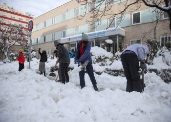 Varios voluntarios despejan con palas el acceso a una de las entradas del Hospital Gregorio Marañón de Madrid, cubierto de una gruesa capa de nieve tras el paso de la borrasca Filomena. Foto: David Fernández/EFE