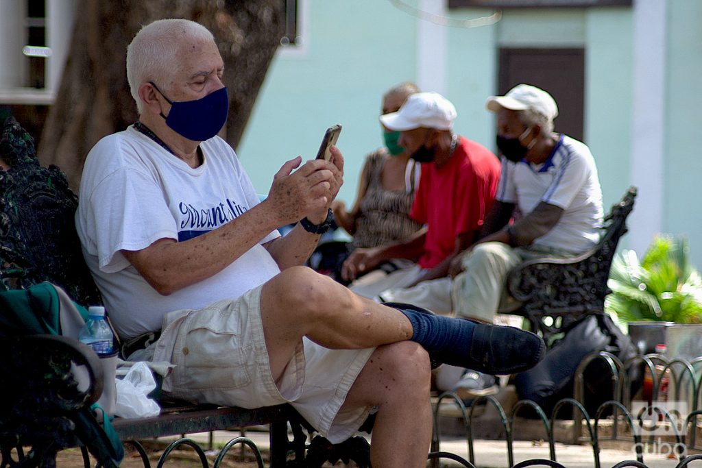 Un hombre revisa internet en su móvil en un parque de La Habana. Foto: Otmaro Rodríguez/Archivo OnCuba.