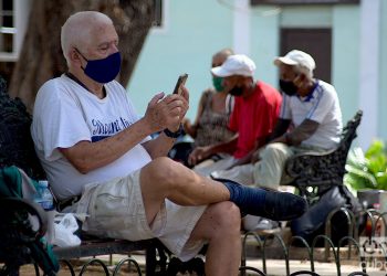 Un hombre revisa internet en su móvil en un parque de La Habana. Foto: Otmaro Rodríguez/Archivo OnCuba.