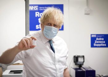 El primer ministro británico Boris Johnson sostiene una dosis de la vacuna de Oxford AstraZeneca contra la COVID-19. Foto: Stefan Rousseau/Pool Foto vía AP).