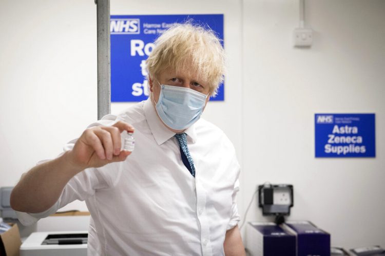 El primer ministro británico Boris Johnson sostiene una dosis de la vacuna de Oxford AstraZeneca contra la COVID-19. Foto: Stefan Rousseau/Pool Foto vía AP).