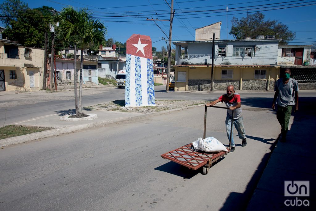 Un hombre transporta mercancía en una carretilla, en el poblado de Regla, en La Habana. Foto: Otmaro Rodríguez.