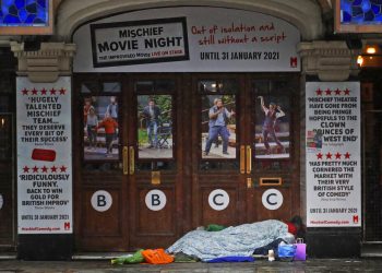 Una persona sin hogar duerme a la entrada de un teatro cerrado por la pandemia del coronavirus, en Londres, el 8 de febrero de 2021. Foto: Frank Augstein/Ap.