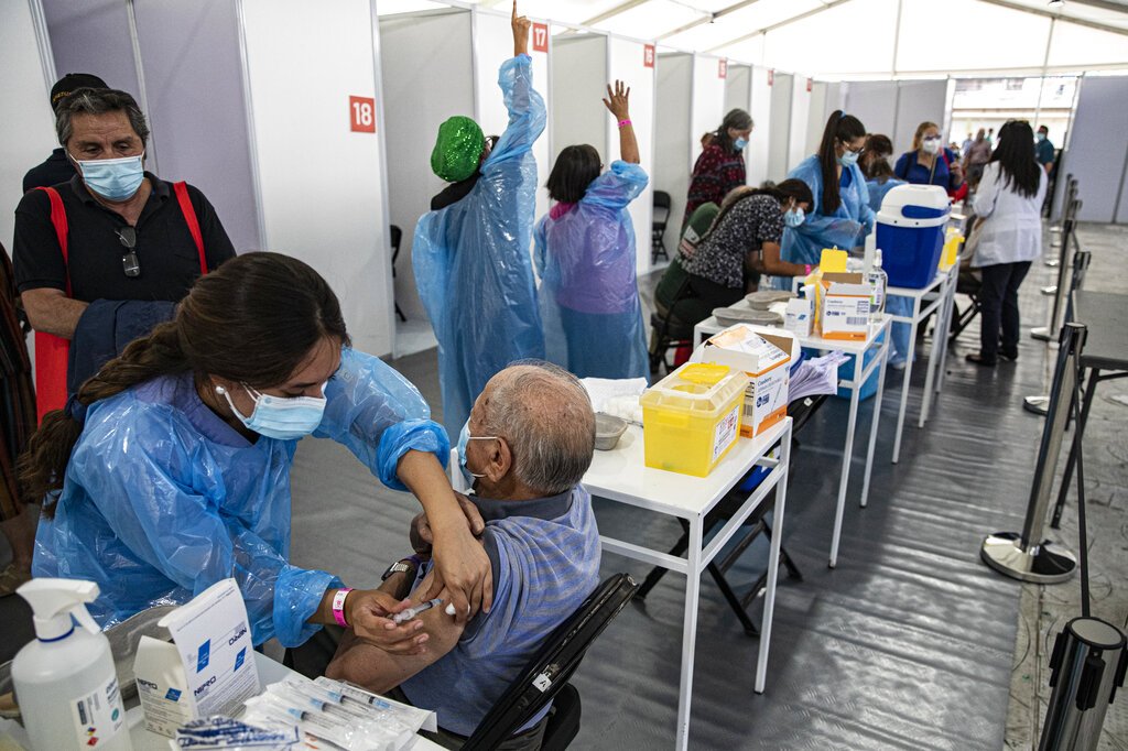 Un trabajador de la salud inocula a un anciano con una dosis de la vacuna Sinovac COVID-19 en un centro de inmunización instalado en el Estadio Bicentenario en Santiago de Chile. Foto: Esteban Félix / AP / Archivo.