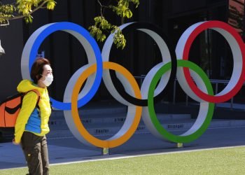 Una mujer camina frente a los anillos olímpicos en Tokio, el miércoles 10 de marzo de 2021. Foto: AP/Koji Sasahara.