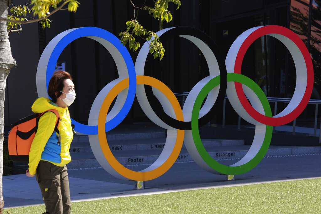 Una mujer camina frente a los anillos olímpicos en Tokio, el miércoles 10 de marzo de 2021. Foto: AP/Koji Sasahara.
