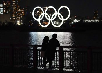 Una pareja frente al despliegue de los anillos olímpicos en el distrito de Odaiba en Tokio, el miércoles 3 de marzo de 2021. Foto: AP/Eugene Hoshiko.