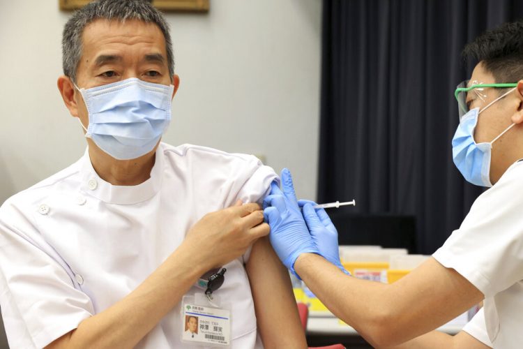 Terumi Kamisawa (izquierda), presidente del Centro Komagome, el hospital metropolitano de Tokio para cáncer e infecciones, recibe una dosis de la vacuna contra el coronavirus desarrollada por Pfizer y BioNTech en el hospital, en Tokio, el 5 de marzo de 2021. Foto: Yoshikazu Tsuno/AP.