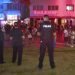 En esta imagen tomada de un video se ve a unos policías vigilando el sábado 20 de marzo de 2021 mientras una muchedumbre recorre una calle de South Beach, Miami. Foto: WPLG vía AP.