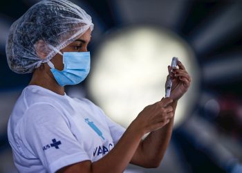 Una trabajadora de salud prepara dosis de la vacuna de Astrazeneca contra la covid-19 en la cuadra de Portela, una de las comparsas de carnaval más tradicionales de Río de Janeiro, Brasil. Foto: André Coelho / EFE.