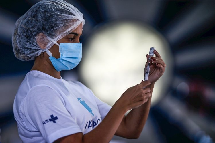 Una trabajadora de salud prepara dosis de la vacuna de Astrazeneca contra la covid-19 en la cuadra de Portela, una de las comparsas de carnaval más tradicionales de Río de Janeiro, Brasil. Foto: André Coelho / EFE.