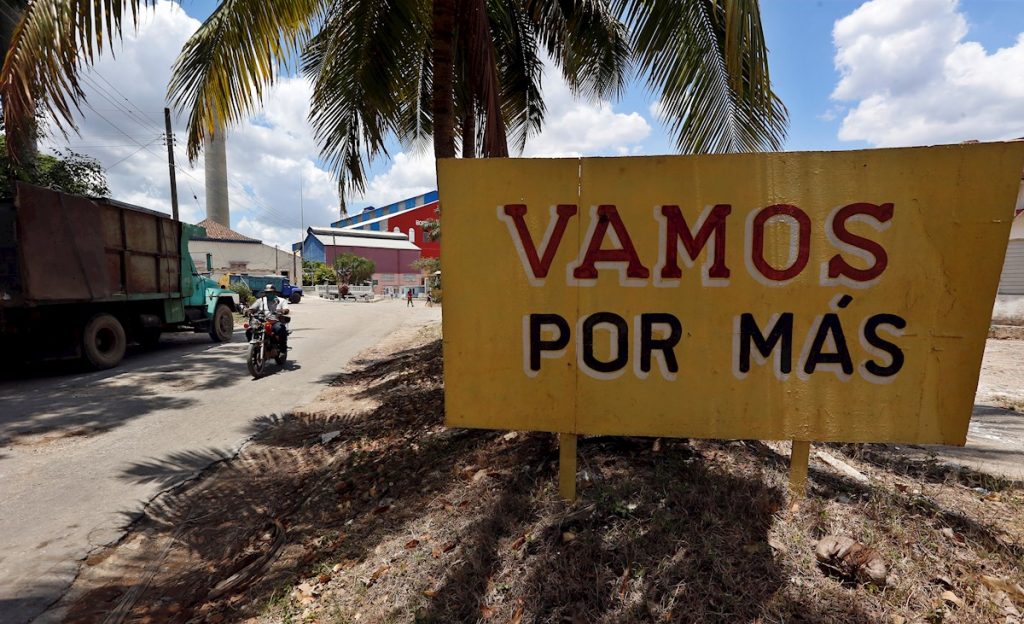 Vista de un cartel que incentiva a los cubanos a producir más azúcar, cerca a la entrada del Central Azucarero Boris Luis Santa Coloma, que permanece en paro de su producción. Foto: EFE/Ernesto Mastrascusa/Archivo.