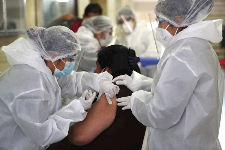 Personal médico vacuna a una persona contra la COVID-19 en La Paz, Bolivia. Foto: Martin Alipaz / EFE / Archivo.