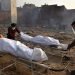 Un cuerpo es preparado para los últimos ritos en piras funerarias para las víctimas de COVID-19, en un campo de cremación improvisado en Nueva Delhi, la India, el 1 de mayo de 2021. Foto: Idrees Mohammed / EFE.