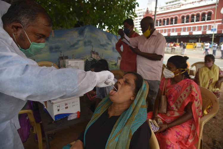 Un trabajador sanitario toma a una mujer una muestra para una prueba diagnóstica del coronavirus SARS-CoV-2, en Chennai, la India. Foto: Idrees Mohammed / EFE.