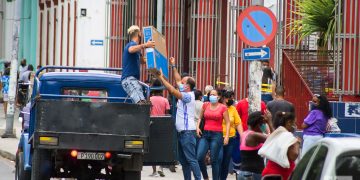Personas cargan mercancías compradas en Moneda Libremente Convertible, en el centro comercial Carlos III, en La Habana. Foto: Otmaro Rodríguez.