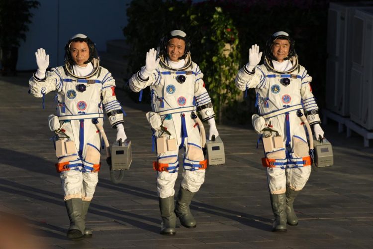 Los astronautas chinos Tang Hongbo, Nie Haisheng y Liu Boming saludan mientras se preparan para abordar el despegue en el Centro de Lanzamiento de Satélites de Jiuquan en Jiuquan, en el noroeste de China el jueves 17 de junio de 2021. Foto: Ng Han Guan/AP.