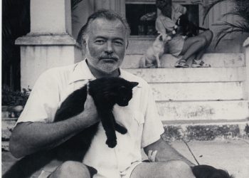 Hemingway y Mary en el portal de su casa habanera con los gatos. | Archivo PBS