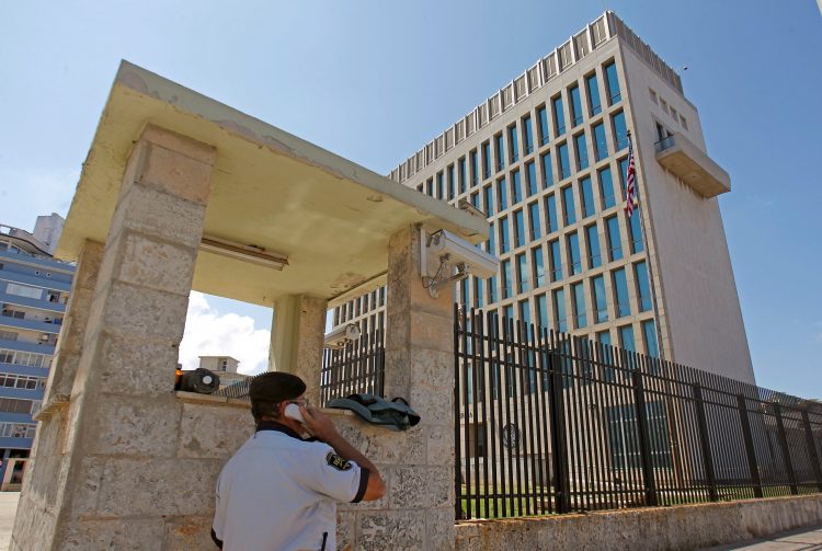 Un guarda de seguridad habla por teléfono frente al edificio de la embajada de EEUU en La Habana. | Reuters