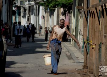 Un hombre carga agua en una tanqueta en la Calle Tejadillo. Foto: Otmaro Rodríguez