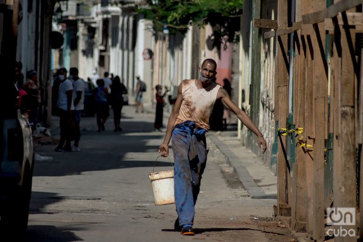 Un hombre carga agua en una tanqueta en la Calle Tejadillo. Foto: Otmaro Rodríguez