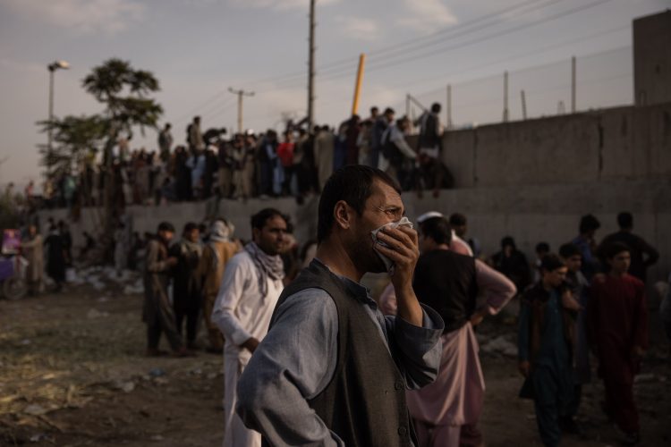 Un hombre se seca las lágrimas frente al muro del aeropuerto de Kabul, donde la evacuación es lenta y dìficil. | Foto: NYT