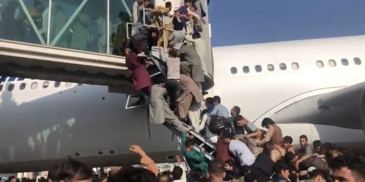 Decenas de afganos intentan lograr un espacio en un avión en el aeropuerto de Kabul en fuga de los talibanes. | Foto:  AFP/France 24