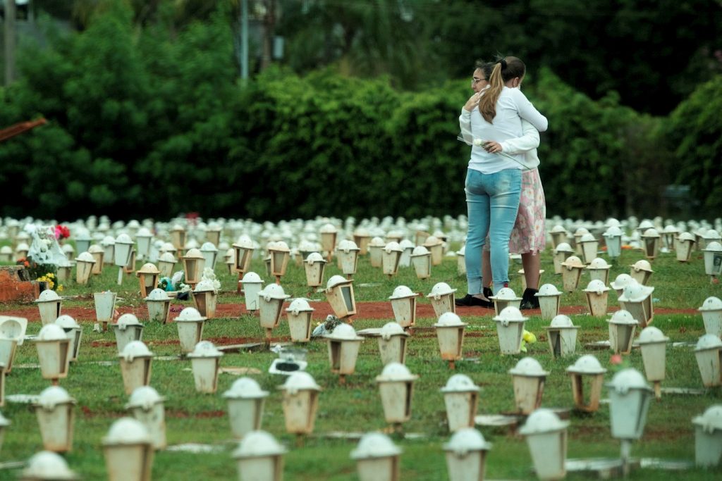 Dos mujeres lloran durante el entierro de una víctima de la COVID-19, en el cementerio de Campo da Esperança en la ciudad de Brasilia (Brasil). Foto: EFE/Joédson Alves/Archivo.