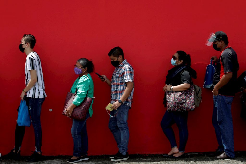 Un grupo de personas en fila antes de ser vacunados contra la COVID-19, en el estacionamiento del estadio Rommel Fernández, en Ciudad de Panamá (Panamá). Foto: EFE/Bienvenido Velasco/Archivo.