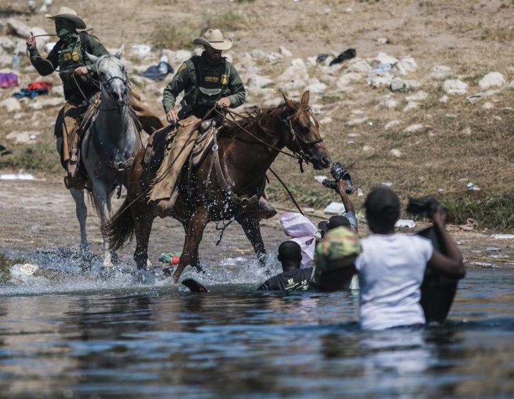 Agentes fronterizos intentan contener a migrantes haitiaos mientras cruzan el Río Grande desde Ciudad Acuña, México, hacia Del Río, Texas, el domingo 19 de septiembre de 2021. Foto: Félix Márquez/AP.