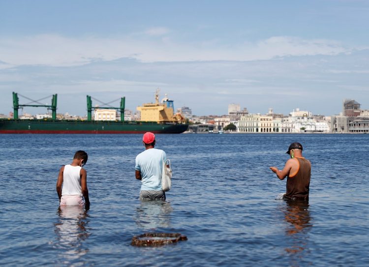 Tres hombres pescan en La Habana. Foto: Yander Zamora/Efe.