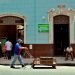 Un hombre mientras camina con una carretilla frente a un policlínico en La Habana, provincia con una de las tasas de incidencias más bajas al cierre de mes. Foto: Ernesto Mastrascusa/Efe.