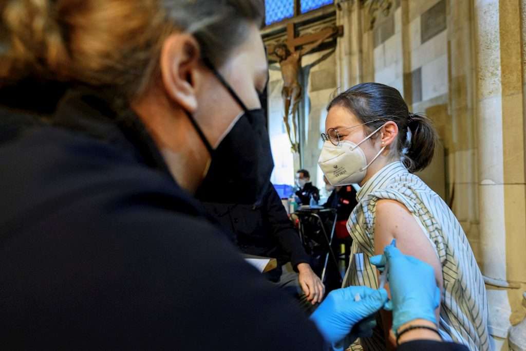Una mujer es vacunada contra la covid-19 en el interior de la catedral de Saint Stephen, en Viena. Foto: Christian Bruna / EFE.