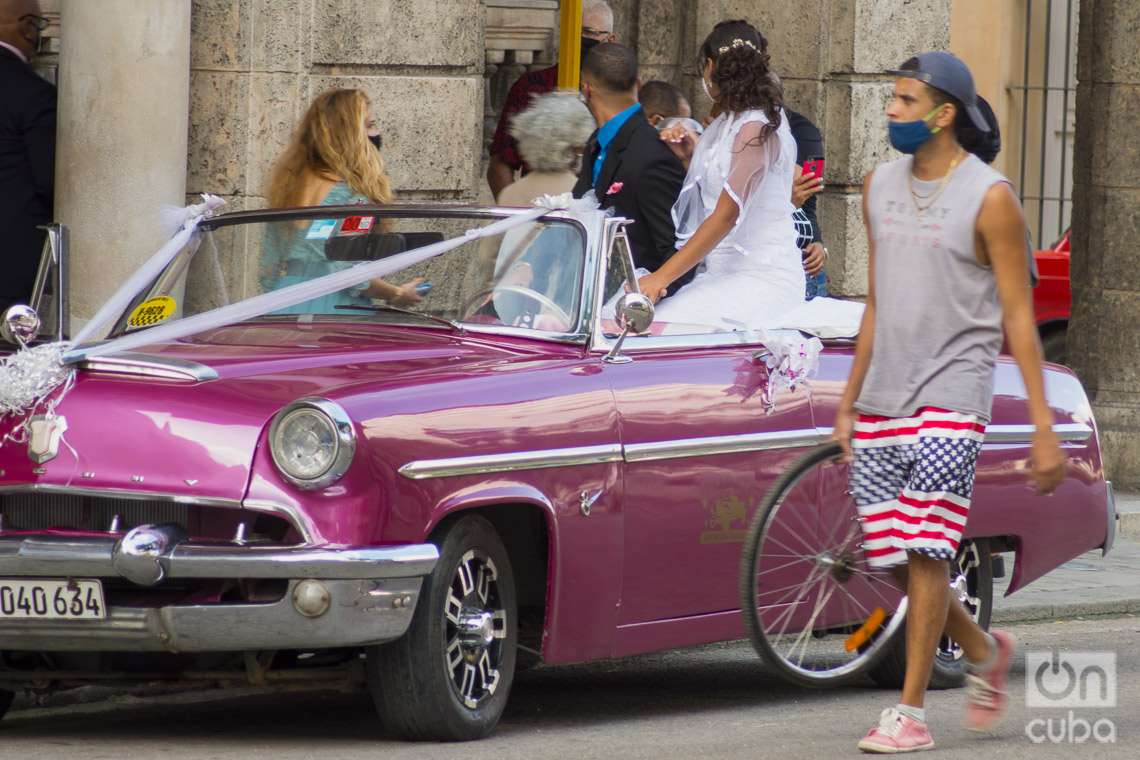 Recién casados montan un auto clásico a la salida del Palacio de los Matrimonios de Prado, en La Habana. Foto: Otmaro Rodríguez.