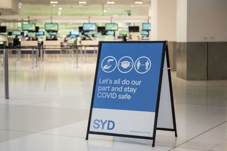 Cartel sobre medidas de protección frente a la COVID-19 en el aeropuerto de Sidney, Australia. Foto: James Gourley / EFE.