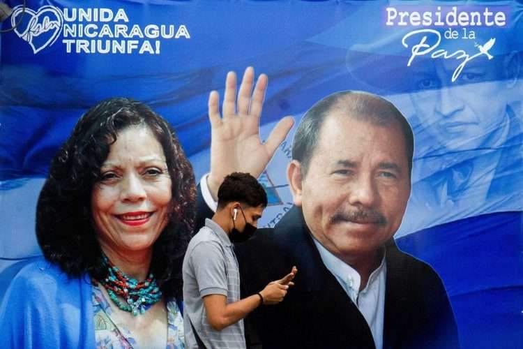 Un nicaragüense pasa delante de un cartel electoral de Daniel Ortega y su esposa Rosario Murillo. Foto: Jorge Díaz/EFE.
