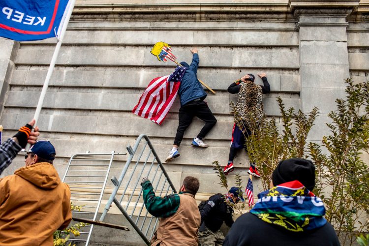 Un manifestante intenta escalar un muro del Capitolio, en Washington, el  6 de enero. | AP (Archivo)