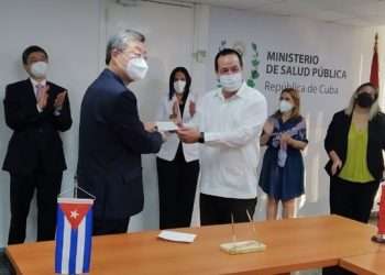 El Dr. José Angel Portal Miranda, ministro cubano de Salud, y Ma Hui, embajador de China en Cuba, sostienen un cheque de 100 mil dólares donado por la nación asiática al sistema sanitario de la Isla. Foto: Minsap / ACN.