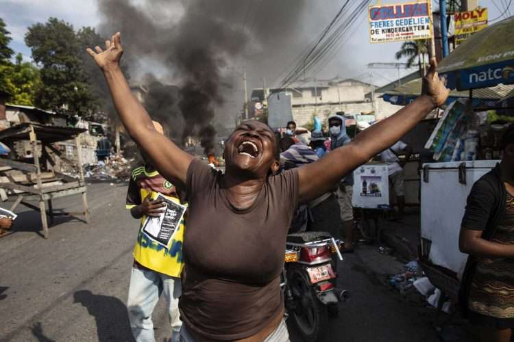 Una mujer manifiesta su desespero en la calle durante los incidentes tras la muerte del mandatario haitiano Jovenel Möise. Foto: Rodrigo Abd / AP / Archivo.