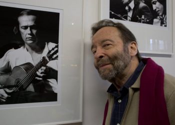 El fotógrafo suizo René Robert junto a una de sus fotos más famosas, del guitarrista Paco de Lucía. | Foto: Jean-Louis Duzert/Avalon