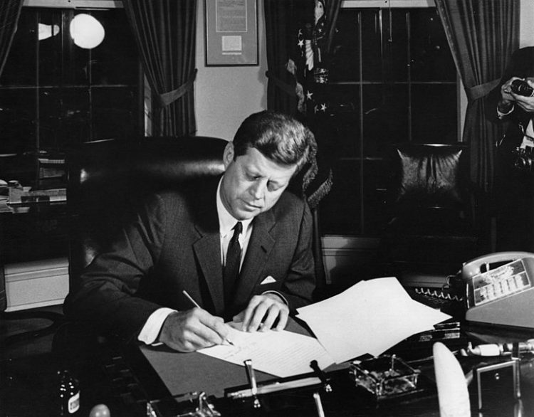 El presidente Kennedy firma la Proclamación 3504 autorizando la cuarentena naval de Cuba (23 de octubre de 1962), a ocho meses del anuncio del embargo y en plena Crisis de los Misiles en Cuba. Foto: Abbie Rowe. Fotografías de la Casa Blanca. Biblioteca y Museo Presidencial John F. Kennedy, Boston