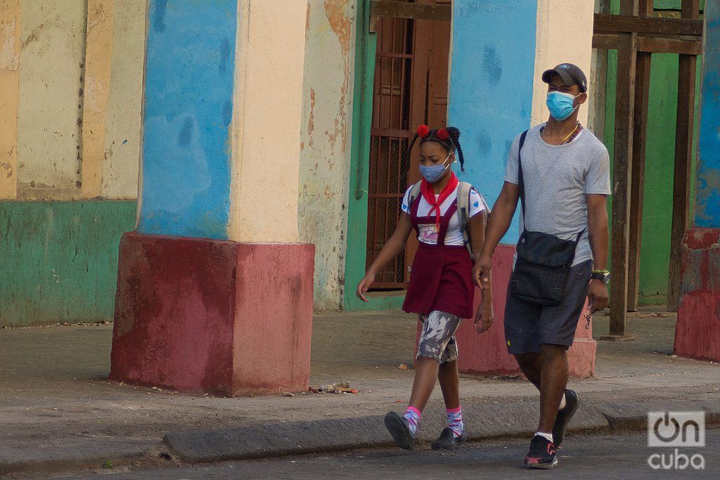 Un hombre lleva a su hija a la escuela, en La Habana. Foto: Otmaro Rodríguez.