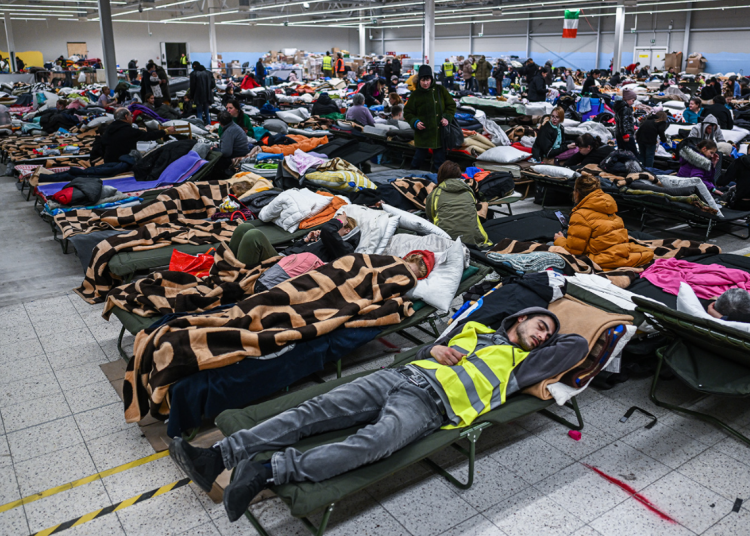 Personas que huyeron de la guerra en Ucrania descansan dentro de un refugio temporal después de ser transportadas desde la frontera entre Polonia y Ucrania el 8 de marzo en Przemysl, Polonia. (Omar Marqués/Getty Images)