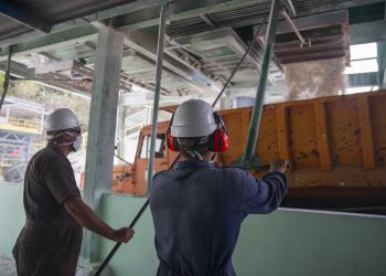 Dos obreros trabajan en la planta minera Coco Peredo, en la occidental provincia cubana de Mayabeque. Foto: Yander Zamora / EFE.