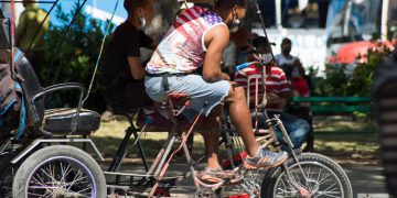 Un conductor de bicitaxi viste una camiseta con la bandera de Estados Unidos, en La Habana, el martes 17 de mayo de 2022. Foto: Otmaro Rodríguez.