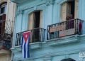 Un bandera cubana y un cartel de apoyo a los familiares de las víctimas de la explosión en el hotel Saratoga, en el balcón de un edificio cercano al lugar. Foto: Otmaro Rodríguez.