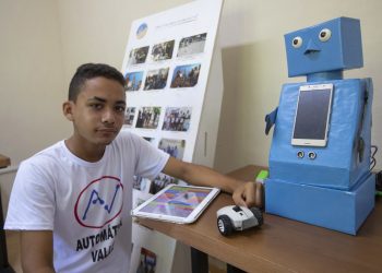 El niño cubano Abel Robago posa junto al robot con el que ganó un concurso nacional de robótica, en el Club de Computación Arrollo I, en La Habana. Foto: Yander Zamora / EFE.