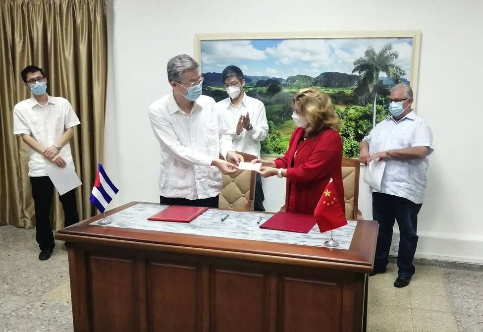El embajador chino en Cuba, Ma Hui, entrega a la viceministra de Comercio Exterior y la Inversión Extranjera de la Isla, Déborah Rivas, un cheque de 100 mil dólares como donativo al país caribeño. Foto: @MINCEX_CUBA / Twitter.