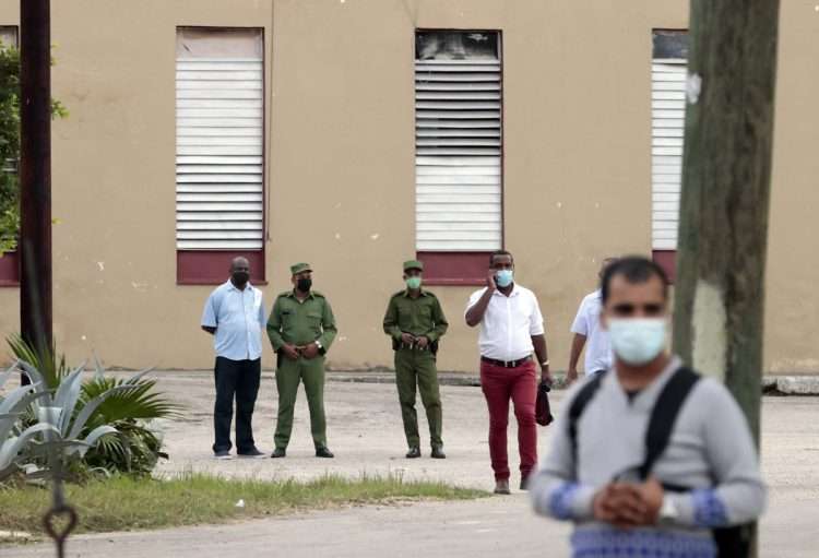 Varios policías controlan el acceso al tribunal donde se efectuara el juicio contra los artistas y disidentes cubanos Luis Manuel Otero Alcántara y Maiykel Castillo, "El Osorbo", en La Habana. Foto: Ernesto Mastrascusa/Efe.